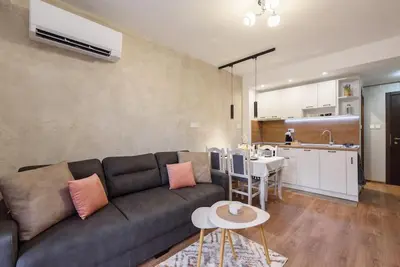 a living room with a couch and a kitchen at Vutovi's corner made with care in Bansko