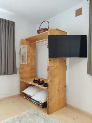 a room with a tv on a wall at Калиновата къща in Stoykite