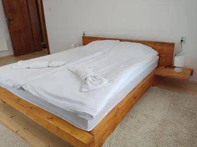 a bed with white sheets and towels on it at Калиновата къща in Stoykite