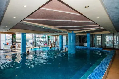 a large swimming pool with people in the water at Pirin's Hidden Gem BB & SKI & SPA in Bansko