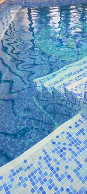 a swimming pool with blue tiles on the water at Guest house Elora in Chiflik