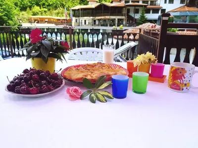a white table with a pizza and fruit on it at Guest house Elora in Chiflik