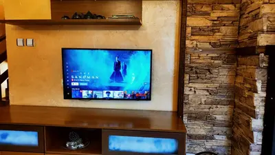 a flat screen tv sitting on top of a wall at Guest House Chepelare in Chepelare