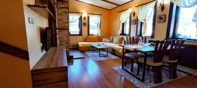a living room with a table and a couch at Guest House Chepelare in Chepelare