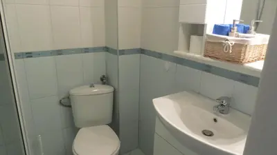 a white bathroom with a toilet and a sink at Apartment Sophie in Plovdiv