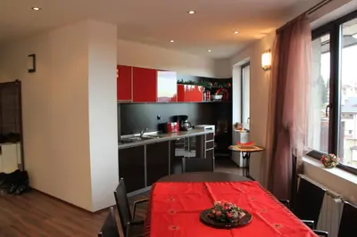 a kitchen and dining room with a red table in a room at Stenata Boutique Apartments in Pamporovo