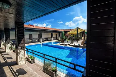a swimming pool next to a house at Complex Jitari in Zhitnitsa