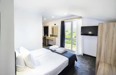 a bedroom with a large bed and a large window at Hit Hot House in Sandanski