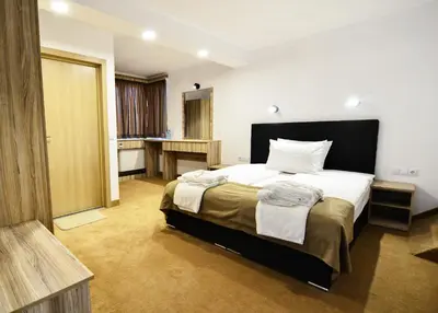 a bedroom with a large bed and a bathroom at Hit Hot House in Sandanski