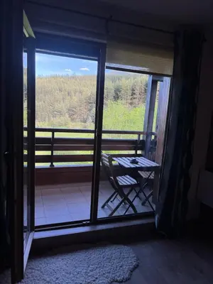 a room with a view of a balcony with a table at Forest View Apartment C34 Bansko in Bansko