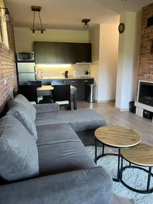 a living room with a couch and tables and a kitchen at Forest View Apartment C34 Bansko in Bansko