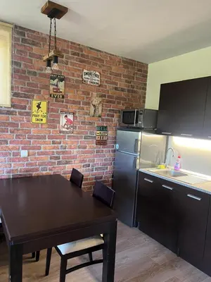 a kitchen with a table and a brick wall at Forest View Apartment C34 Bansko in Bansko