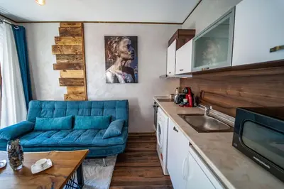 a living room with a blue couch in a kitchen at 650m Ski in&out - Studio - FREE SPA and Parking in Bansko