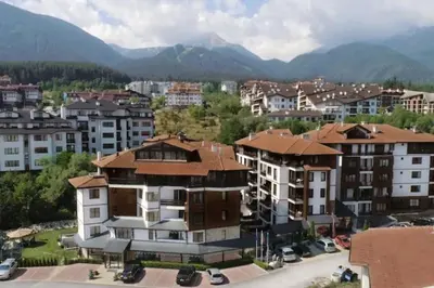 a city with buildings and mountains in the background at 650m Ski in&out - Studio - FREE SPA and Parking in Bansko