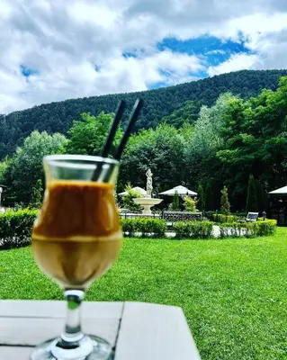 a glass of wine sitting on top of a table at Lorena Holiday Spa Свети Спас in Velingrad