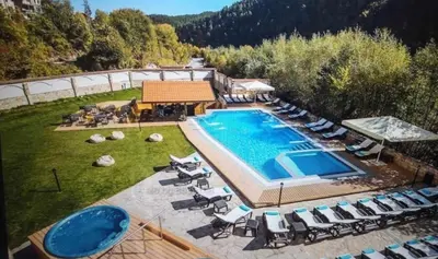 an overhead view of a swimming pool with lounge chairs at Lorena Holiday Spa Свети Спас in Velingrad