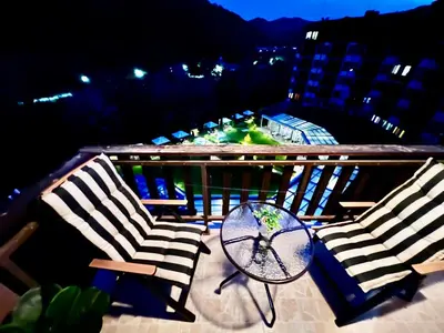 two chairs and a table on a balcony at night at Lorena Holiday Spa Свети Спас in Velingrad