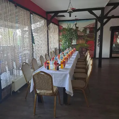 a long table with chairs and orange juice on it at Комплекс Тракийски стан in Asenovgrad