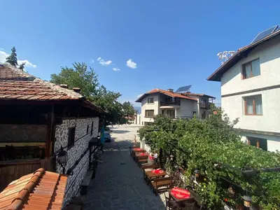 a row of tables and chairs next to a building at Dvata Smurcha Central Apartments - Free Parking in Bansko