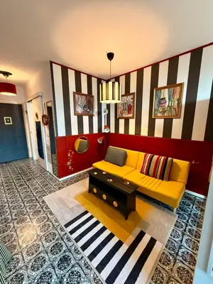 a living room with a yellow couch and a striped wall at Palermo Family designer Apt near UNSS w Fast WiFi in Sofia