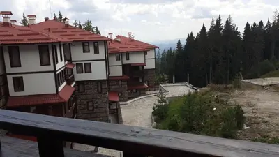 a group of buildings on a hill with trees at Hotel Grand Resor Pamporovo in Pamporovo