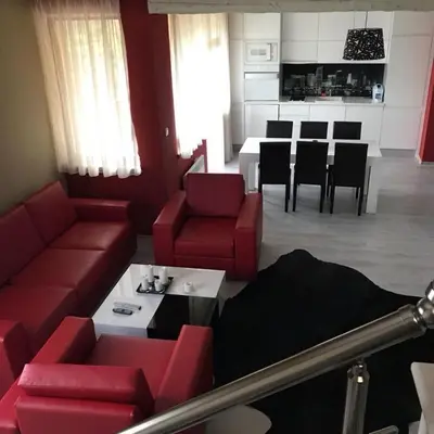 a living room with a red couch and a table at Sequoia Loft apartment in Borovets