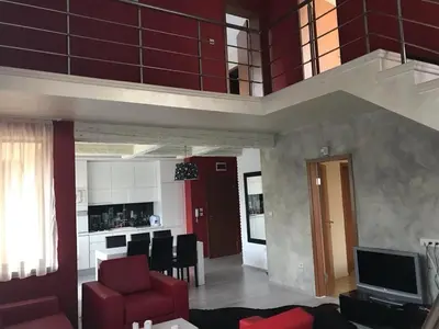 a living room with a red couch and a kitchen at Sequoia Loft apartment in Borovets