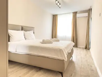 a bedroom with a bed with white sheets and a window at 2BR Business Suite with FREE GYM, by Holiwork Stays in Plovdiv