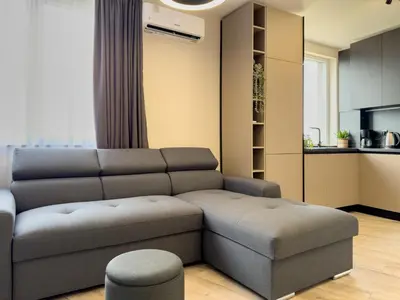 a living room with a couch and a stool at 2BR Business Suite with FREE GYM, by Holiwork Stays in Plovdiv