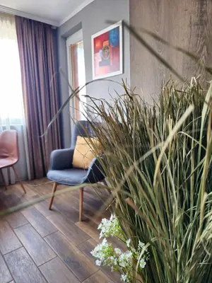 a living room with a blue chair and a plant at Studio Secrets in Plovdiv
