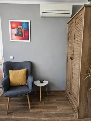 a living room with a blue chair and a table at Studio Secrets in Plovdiv