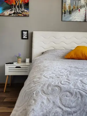 a bedroom with a white bed and a white nightstand at Studio Secrets in Plovdiv