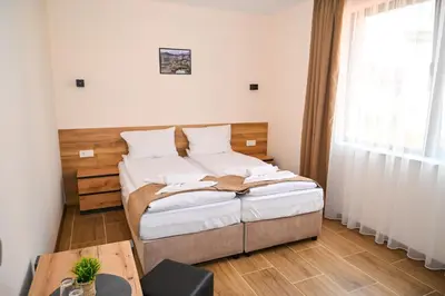 a small bedroom with a bed and a table at Къща Александра 2 in Dobrinishte