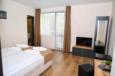 a hotel room with a bed and a television at Къща Александра 2 in Dobrinishte