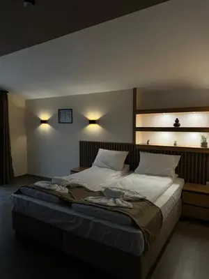 a bedroom with a large bed with two pillows at Къща Александра 2 in Dobrinishte