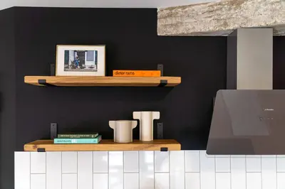 a kitchen with two wooden shelves on a black wall at Vintage Parkside whit Free Parking near Center in Plovdiv