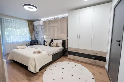 a bedroom with a large bed and a rug at Arni Aparts 1 in Velingrad
