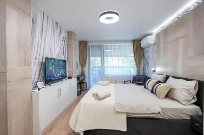 a bedroom with a large bed and a flat screen tv at Arni Aparts 1 in Velingrad