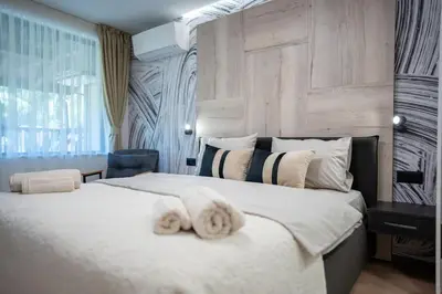 a bedroom with a large white bed with towels on it at Arni Aparts 1 in Velingrad