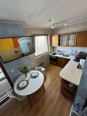 a small kitchen with a white table and a table and a kitchen at 1-Bedroom apt - BathTub - 10mins from SkiLift Gondola - freeWiFi - WorkDesk - Central Heating - Full Kitchen at Edelweiss in Bansko