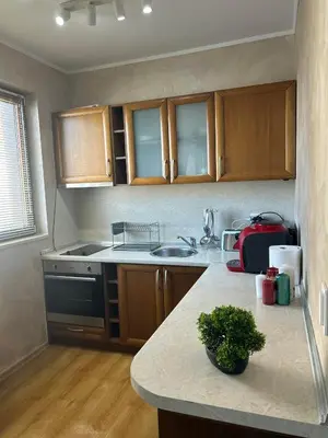 a kitchen with wooden cabinets and a counter top at 1-Bedroom apt - BathTub - 10mins from SkiLift Gondola - freeWiFi - WorkDesk - Central Heating - Full Kitchen at Edelweiss in Bansko
