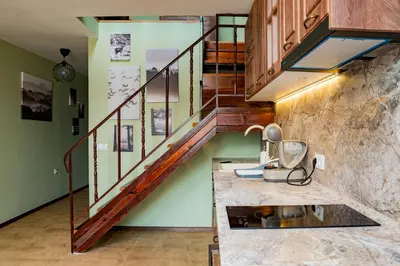 a staircase in a kitchen with green walls at Alpine Retreat Maisonette in Bansko