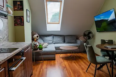 a living room with a couch and a table at Alpine Retreat Maisonette in Bansko