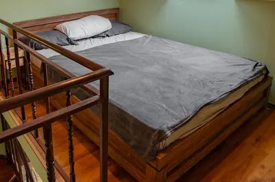 a bed in a room next to a staircase at Alpine Retreat Maisonette in Bansko