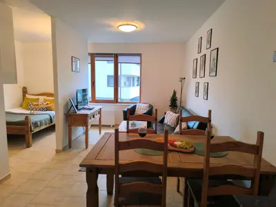 a living room with a wooden table and chairs at Pine`s Lodge - Cozy studio with free Bottle of Wine, private WiFi, free Parking in Bansko