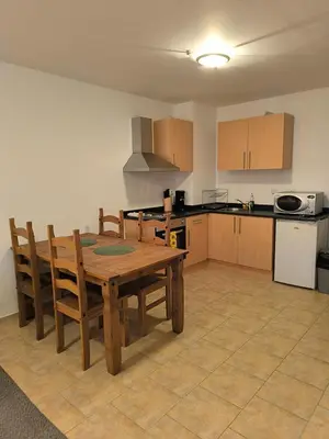 a kitchen with a wooden table and wooden chairs at Pine`s Lodge - Cozy studio with free Bottle of Wine, private WiFi, free Parking in Bansko