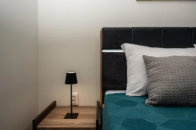 a bedroom with a bed and a lamp on a table at Апартамен за гости Панови in Plovdiv