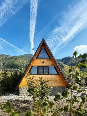 a small wooden cabin with a triangular roof at Алпийска вила в полите Рила in Resilovo