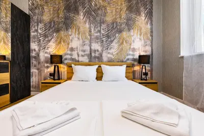 a bedroom with a white bed with two lamps at The Urban Nest-2BD Apartment with a Terrace by Flat Mаnager in Plovdiv
