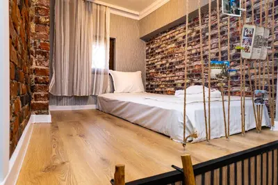 a bedroom with a bed and a brick wall at The Urban Nest-2BD Apartment with a Terrace by Flat Mаnager in Plovdiv